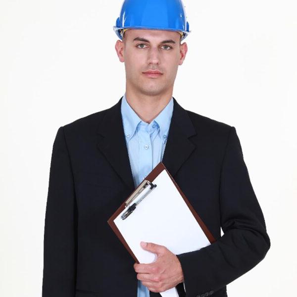 A man wearing a hard hat and holding a clipboard