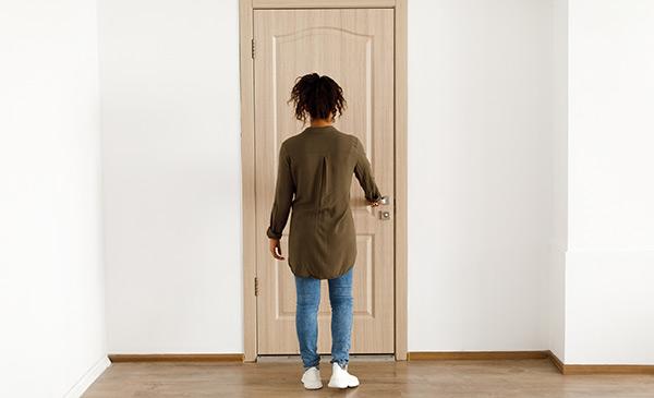 young women opening her apartment door